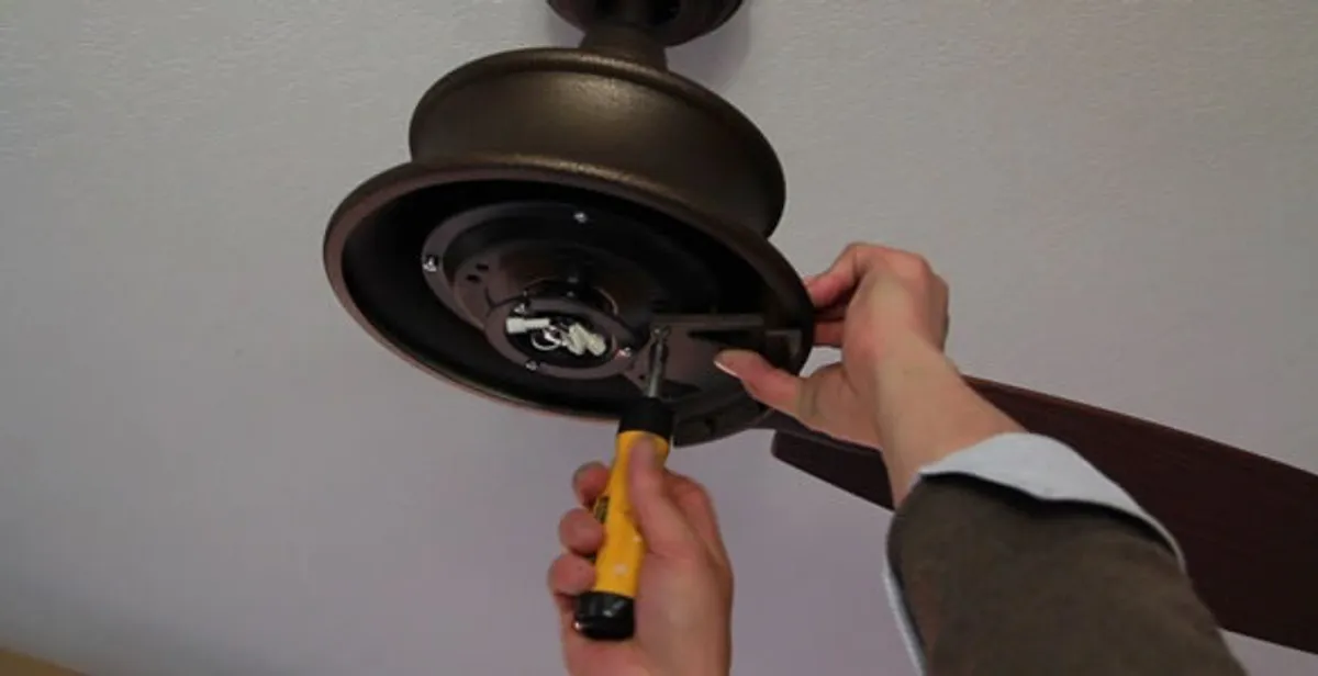 Electrician installing ceiling fan mounting bracket and fixture in Scottsdale, AZ